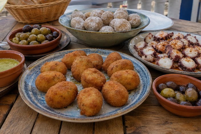 Spanish tapas with croquetas, papas arrugadas, pulpo, olives, and mojo sauces.