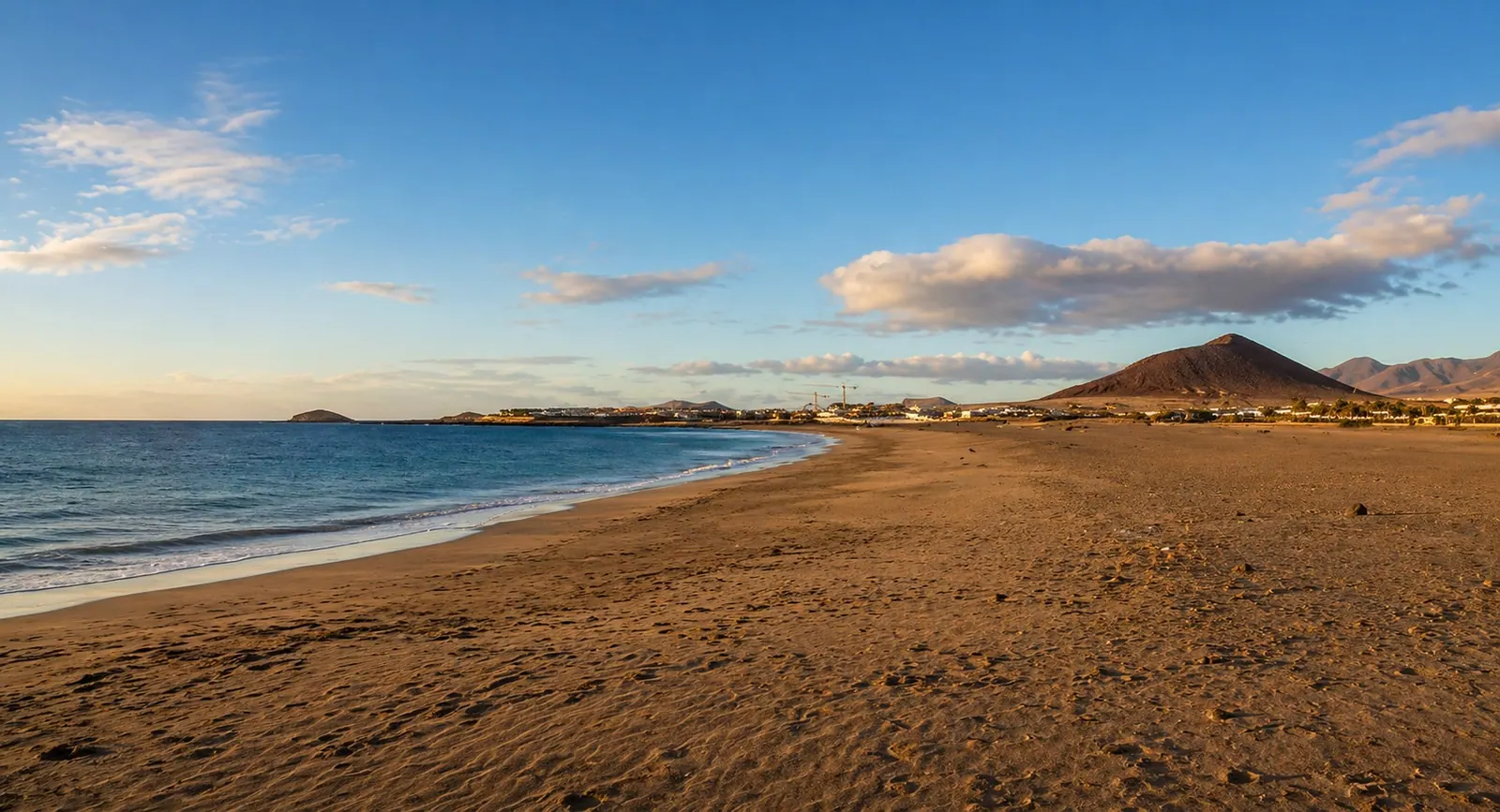 View of Playa de la Tejita with open sand and Montaña Roja nearby.